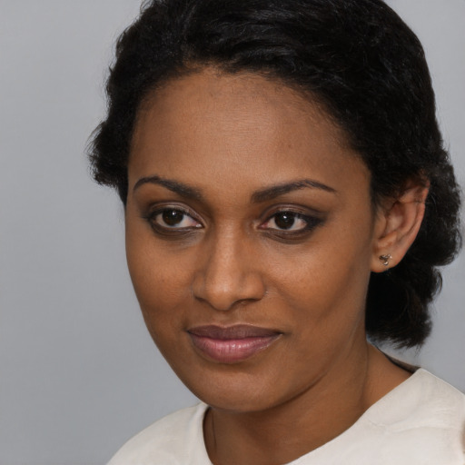 Joyful black young-adult female with short  black hair and brown eyes