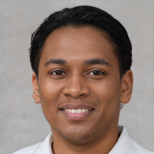 Joyful latino young-adult male with short  black hair and brown eyes