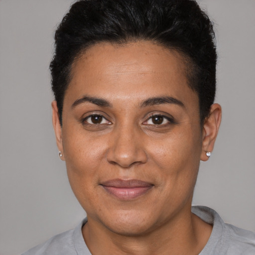 Joyful latino adult female with short  black hair and brown eyes