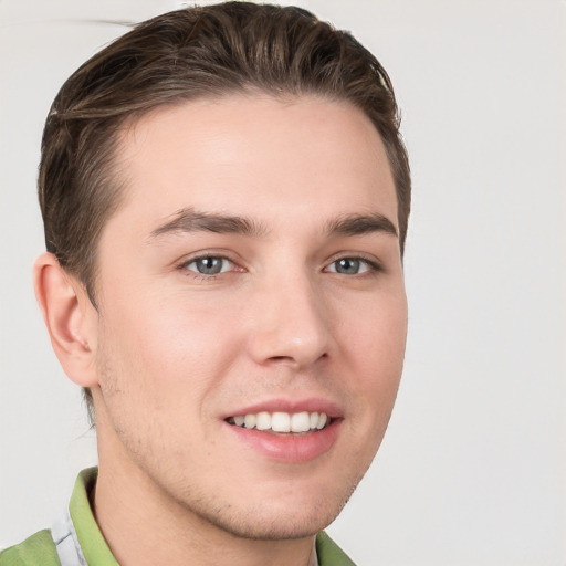 Joyful white young-adult male with short  brown hair and grey eyes