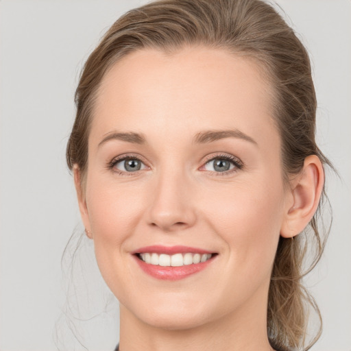 Joyful white young-adult female with medium  brown hair and grey eyes