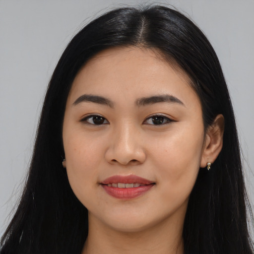 Joyful latino young-adult female with long  black hair and brown eyes