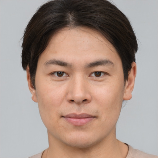 Joyful asian young-adult male with short  brown hair and brown eyes