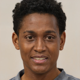 Joyful black young-adult male with short  brown hair and brown eyes