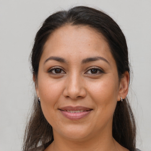 Joyful latino adult female with long  brown hair and brown eyes