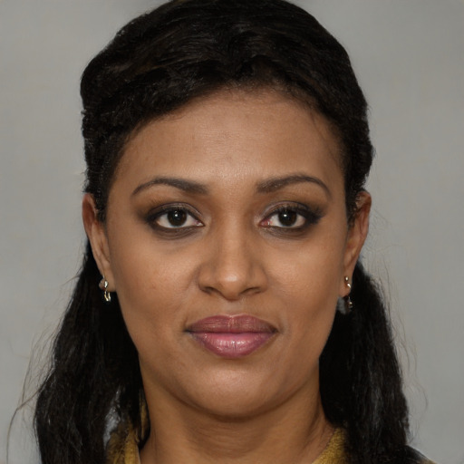 Joyful black young-adult female with long  brown hair and brown eyes