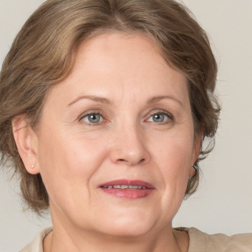 Joyful white adult female with medium  brown hair and blue eyes