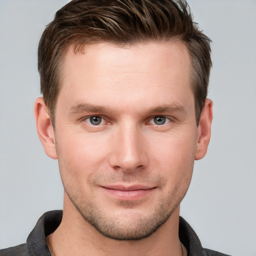 Joyful white young-adult male with short  brown hair and grey eyes