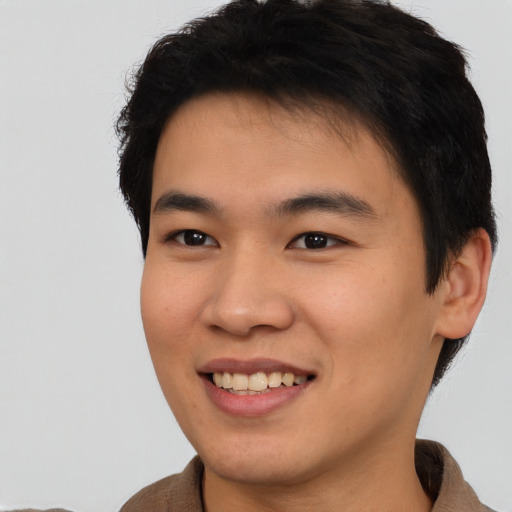 Joyful asian young-adult male with short  brown hair and brown eyes