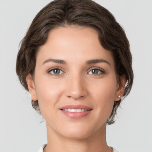 Joyful white young-adult female with medium  brown hair and grey eyes