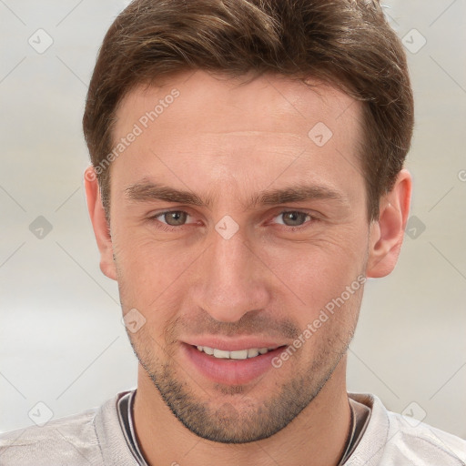 Joyful white young-adult male with short  brown hair and grey eyes