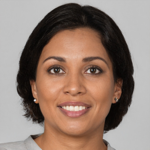 Joyful black young-adult female with medium  brown hair and brown eyes