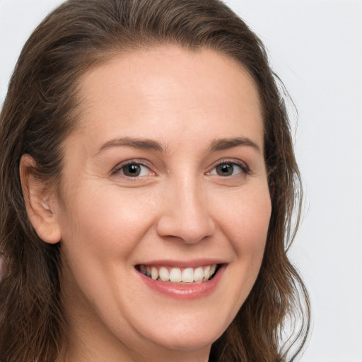 Joyful white young-adult female with long  brown hair and brown eyes