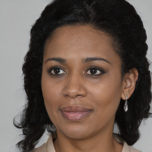 Joyful black young-adult female with medium  brown hair and brown eyes