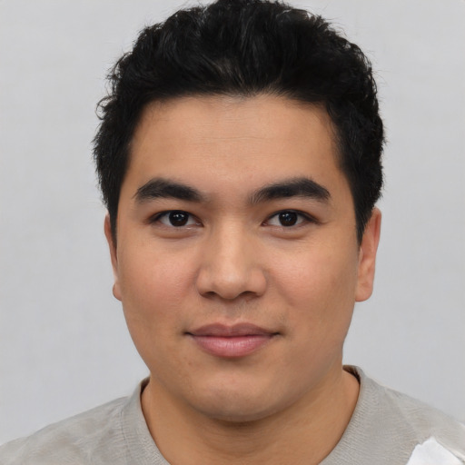 Joyful asian young-adult male with short  black hair and brown eyes
