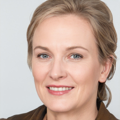 Joyful white adult female with medium  brown hair and grey eyes