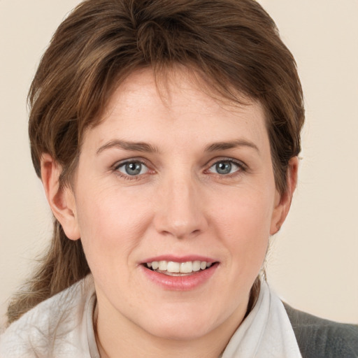 Joyful white young-adult female with medium  brown hair and grey eyes