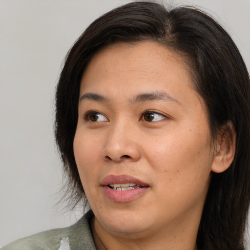 Joyful asian adult female with medium  brown hair and brown eyes