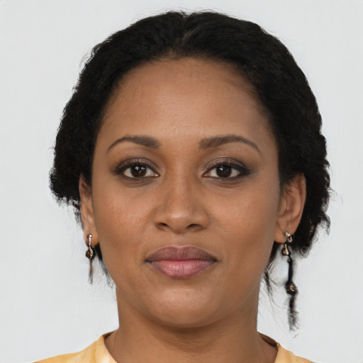Joyful black adult female with short  brown hair and brown eyes