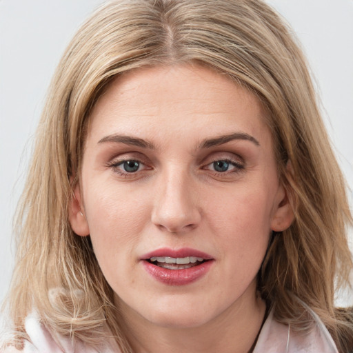 Joyful white young-adult female with long  brown hair and blue eyes