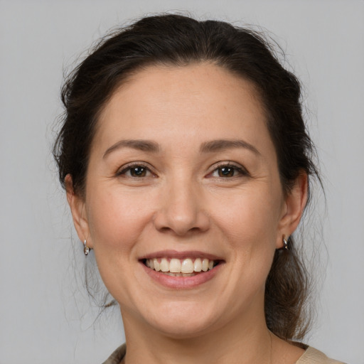 Joyful white adult female with medium  brown hair and brown eyes