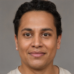 Joyful latino young-adult male with short  brown hair and brown eyes