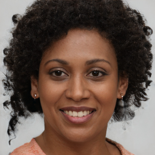 Joyful black young-adult female with medium  brown hair and brown eyes