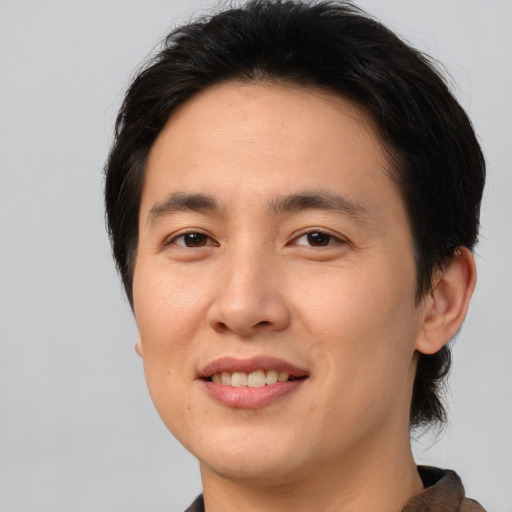 Joyful asian young-adult male with medium  brown hair and brown eyes