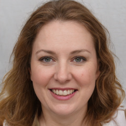 Joyful white young-adult female with long  brown hair and green eyes