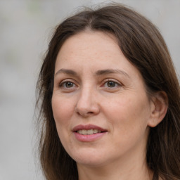 Joyful white adult female with long  brown hair and grey eyes