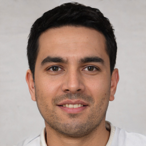 Joyful white young-adult male with short  black hair and brown eyes