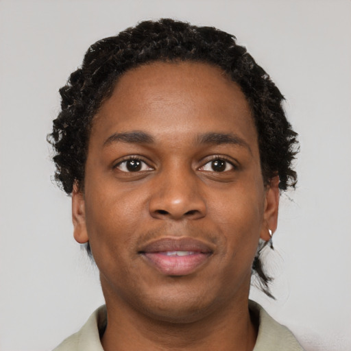 Joyful black young-adult male with short  black hair and brown eyes