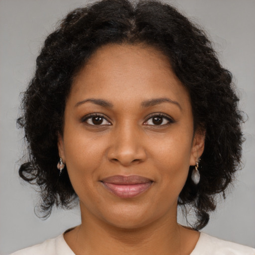 Joyful black adult female with medium  brown hair and brown eyes
