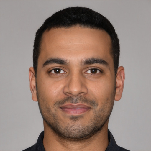 Joyful latino young-adult male with short  black hair and brown eyes