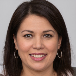 Joyful white adult female with long  brown hair and brown eyes