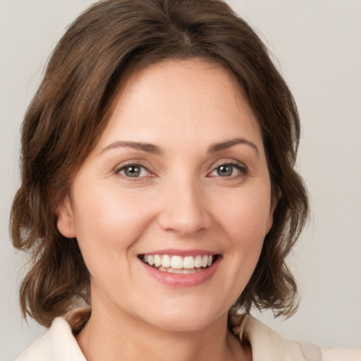 Joyful white young-adult female with medium  brown hair and green eyes