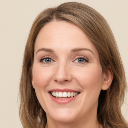 Joyful white young-adult female with medium  brown hair and green eyes