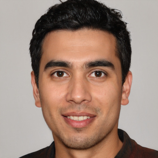 Joyful white young-adult male with short  black hair and brown eyes