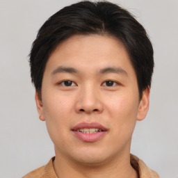 Joyful asian young-adult male with short  brown hair and brown eyes