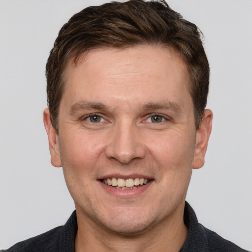 Joyful white adult male with short  brown hair and grey eyes