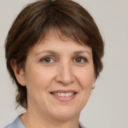 Joyful white adult female with medium  brown hair and grey eyes