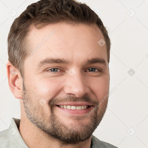 Joyful white young-adult male with short  brown hair and grey eyes