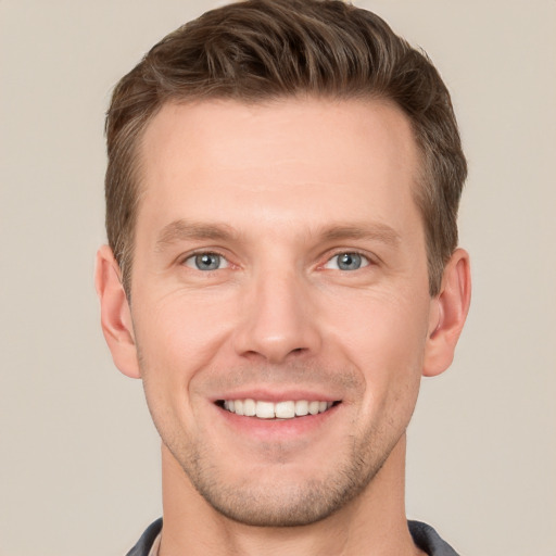 Joyful white young-adult male with short  brown hair and grey eyes