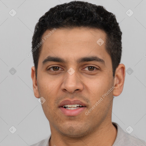 Joyful white young-adult male with short  black hair and brown eyes