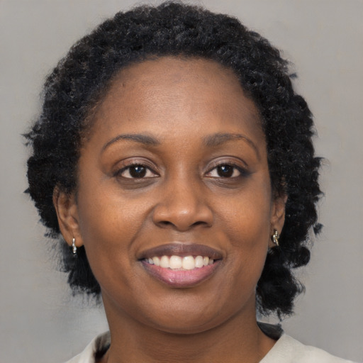 Joyful black young-adult female with medium  brown hair and brown eyes
