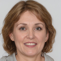 Joyful white adult female with medium  brown hair and grey eyes