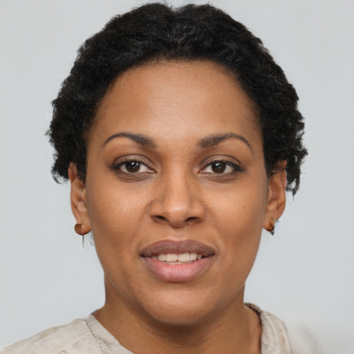 Joyful black young-adult female with short  brown hair and brown eyes