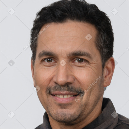 Joyful white adult male with short  black hair and brown eyes