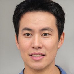 Joyful asian young-adult male with short  brown hair and brown eyes