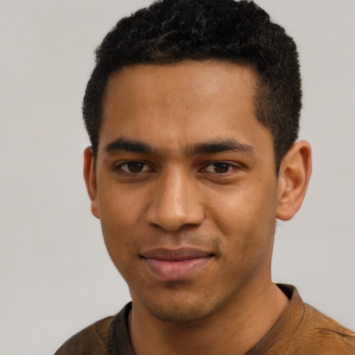 Joyful black young-adult male with short  black hair and brown eyes